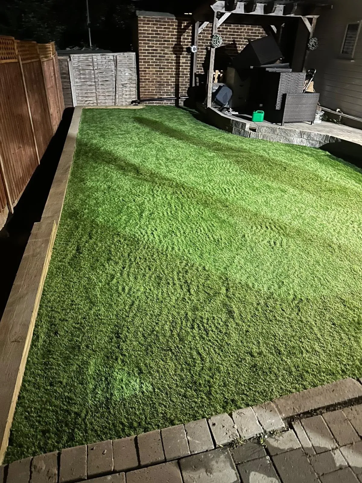 Artificial lawn edged with timber sleepers and a block paved border