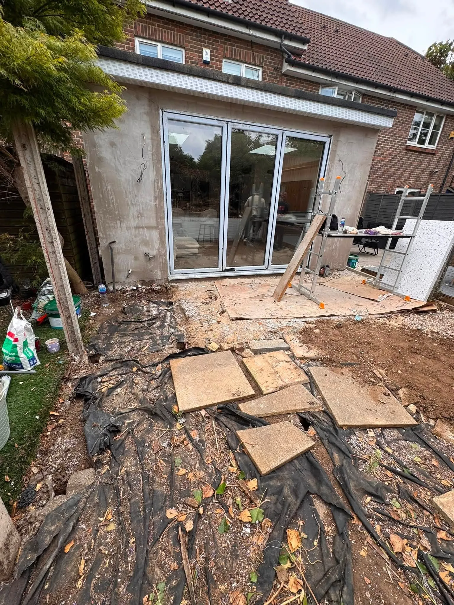 Before: the same spot with old slabs lifted and membrane down beside the extension